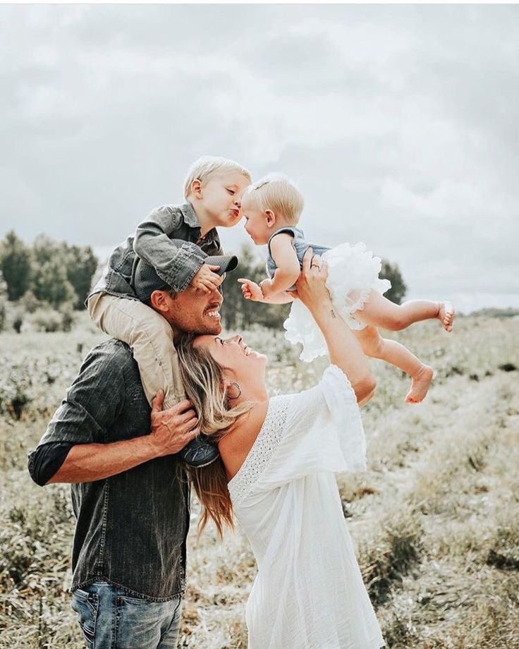 a man and woman holding a baby up in the air