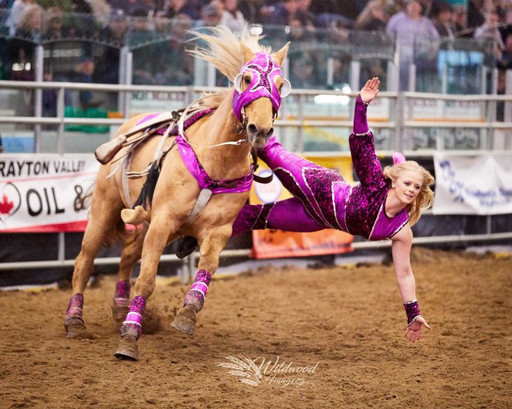 a woman is falling off her horse in the dirt