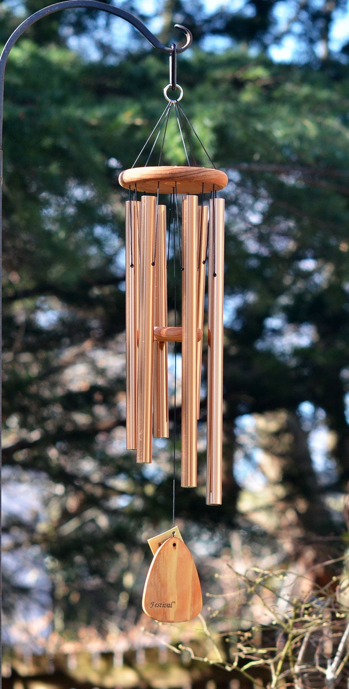 a wooden wind chime hanging from a metal pole