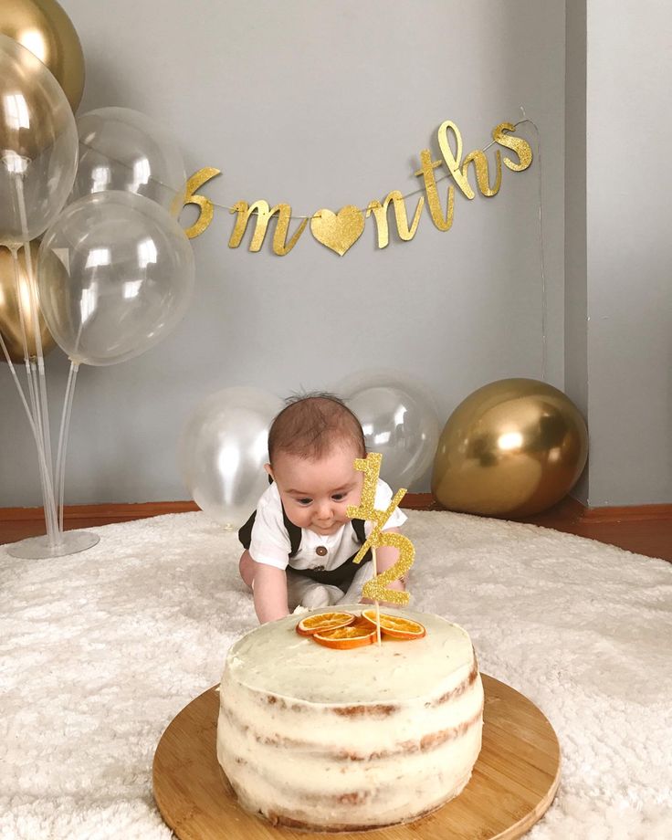 a baby sitting in front of a cake