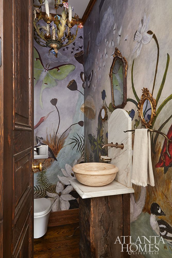 a bathroom with a sink, mirror and wallpaper on the walls in it's corner