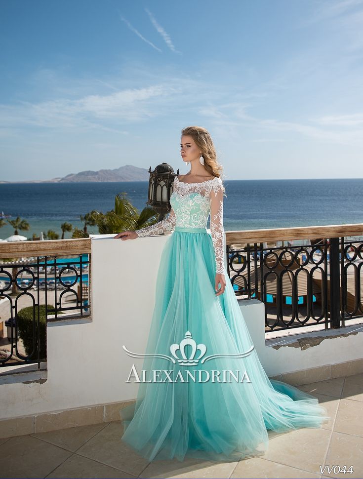 a woman in a blue and white dress is standing on a balcony overlooking the ocean