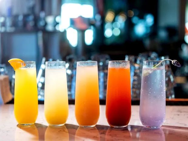 five different types of drinks lined up on a bar