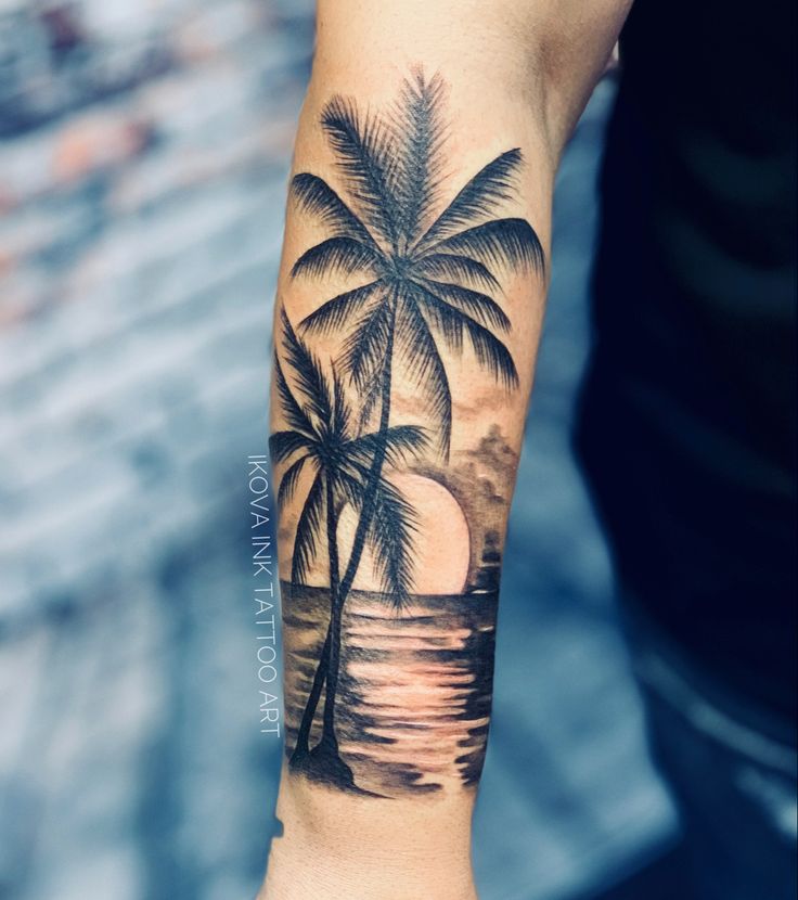 a man's arm with a palm tree and sunset on the beach tattoo design