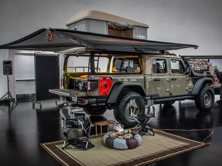 a jeep with a tent attached to it's roof is parked in a garage