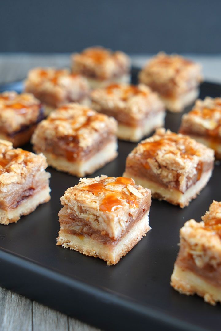 small desserts are arranged on a black plate