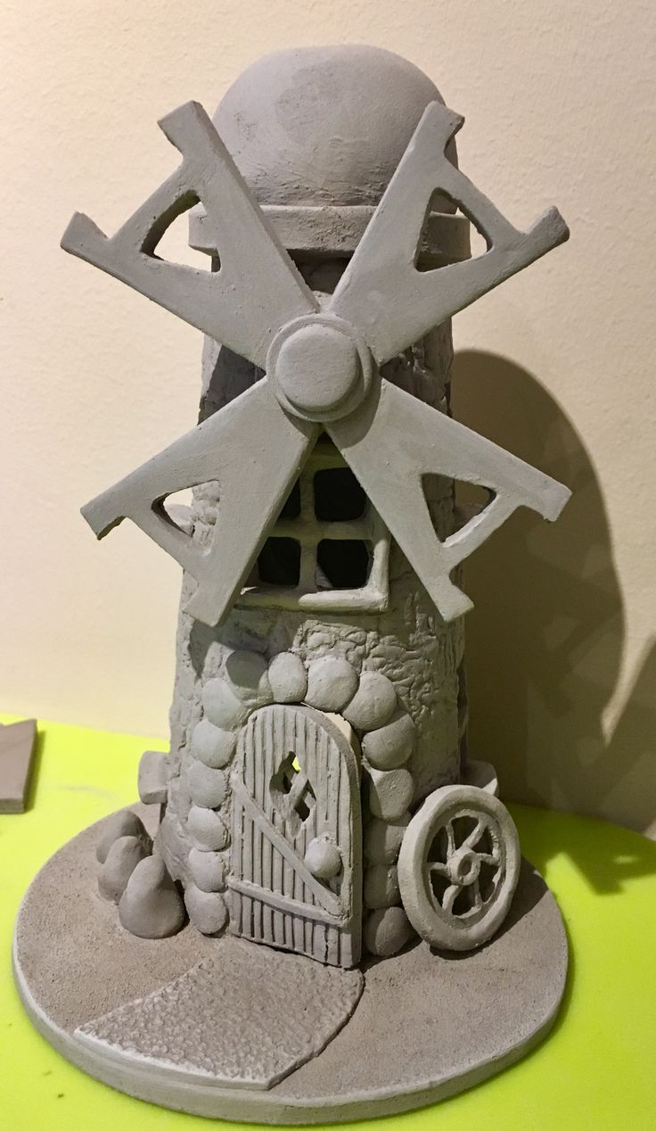 a clay sculpture of a house with a windmill on top