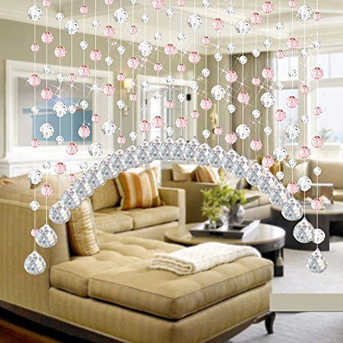 a living room filled with furniture and lots of hanging decorations on the ceiling above it