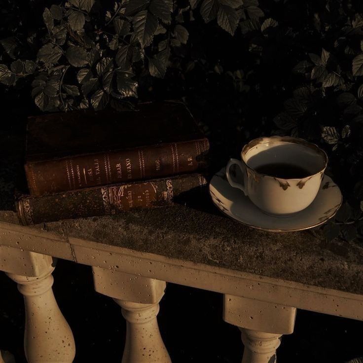 a cup of coffee sitting on top of a table next to two books