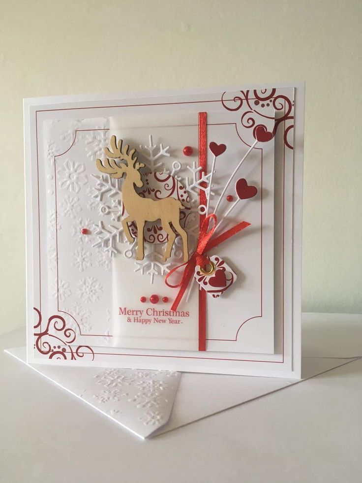 a christmas card with a reindeer and snowflakes on it, sitting on top of a table