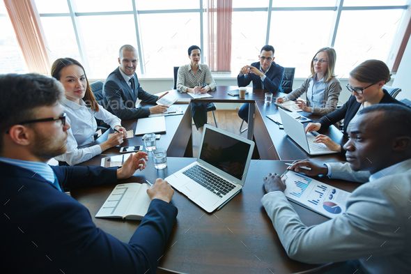 a group of business people sitting around a conference table