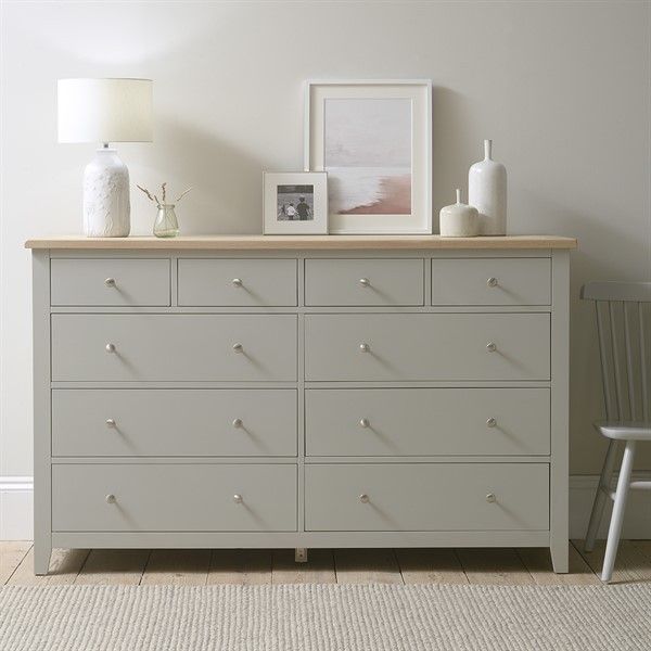 a dresser with many drawers and pictures on top