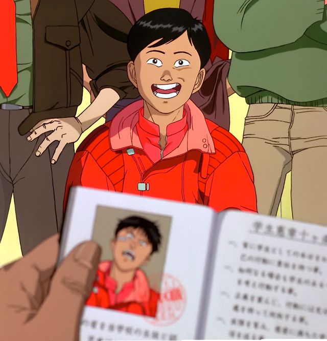 a man holding an open book in front of his face with other people behind him