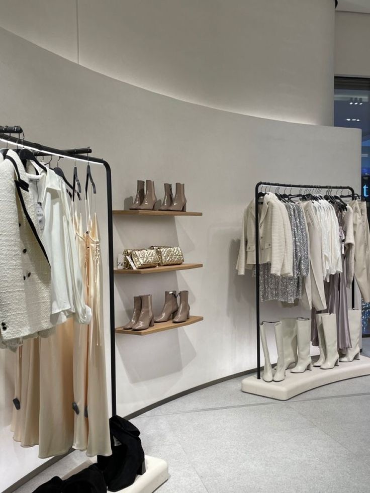 the inside of a clothing store with clothes and shoes on display