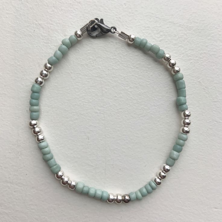 Custom beaded bracelet with turquoise glass and silver beads. Adjustable Sterling Silver Beaded Bracelets With Colorful Beads, Turquoise Stretch Bracelet With Silver Beads, Turquoise Sterling Silver Beaded Bracelets, Silver Beaded Bracelet With Colorful Sterling Beads, Blue Beaded Amazonite Bracelets, Blue Beaded Amazonite Bracelet, Green Sterling Silver Beaded Bracelet, Turquoise Beaded Bracelets With Silver Beads, Turquoise Beaded Bracelets With Silver Beads For Gift