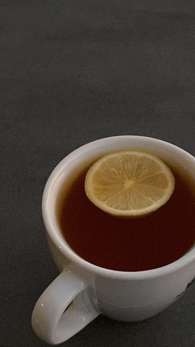 a cup of tea with a lemon slice in it