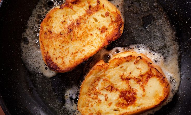 two pieces of bread cooking in a frying pan