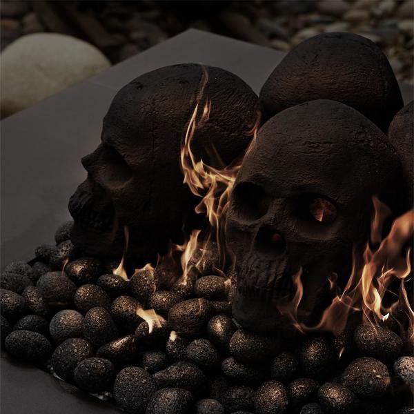 three skulls sitting on top of rocks with flames coming out of their mouths and eyes