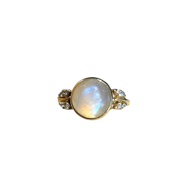 Metaphysically moonstone is known to bring a balancing yin energy to its wearer. This masterfully set iridescent moonstone brings the magic in its 14k yellow gold bezel setting, flanked by eight sparkly diamonds in their whimsical leaf settings. Features a bezel-set approx. 11 x 8mm moonstone Eight flush-set approx. 1mm diamonds Currently size 8, size-able Because we do all our restoration work by hand we can offer a huge array of customization! If you have inquiries about sizing, alterations, o Spiritual Yellow Gold Round Crystal Ring, Heirloom Yellow Gold Moonstone Ring, Oval Cabochon, Heirloom Yellow Gold Oval Cabochon Moonstone Ring, Heirloom Yellow Gold Moonstone Ring, Gold Moonstone Crystal Ring, Celestial Gold Moonstone Ring, Celestial Moonstone Jewelry In Yellow Gold, Celestial Moonstone Yellow Gold Jewelry, Gold Moonstone Ring With Gemstone Accents