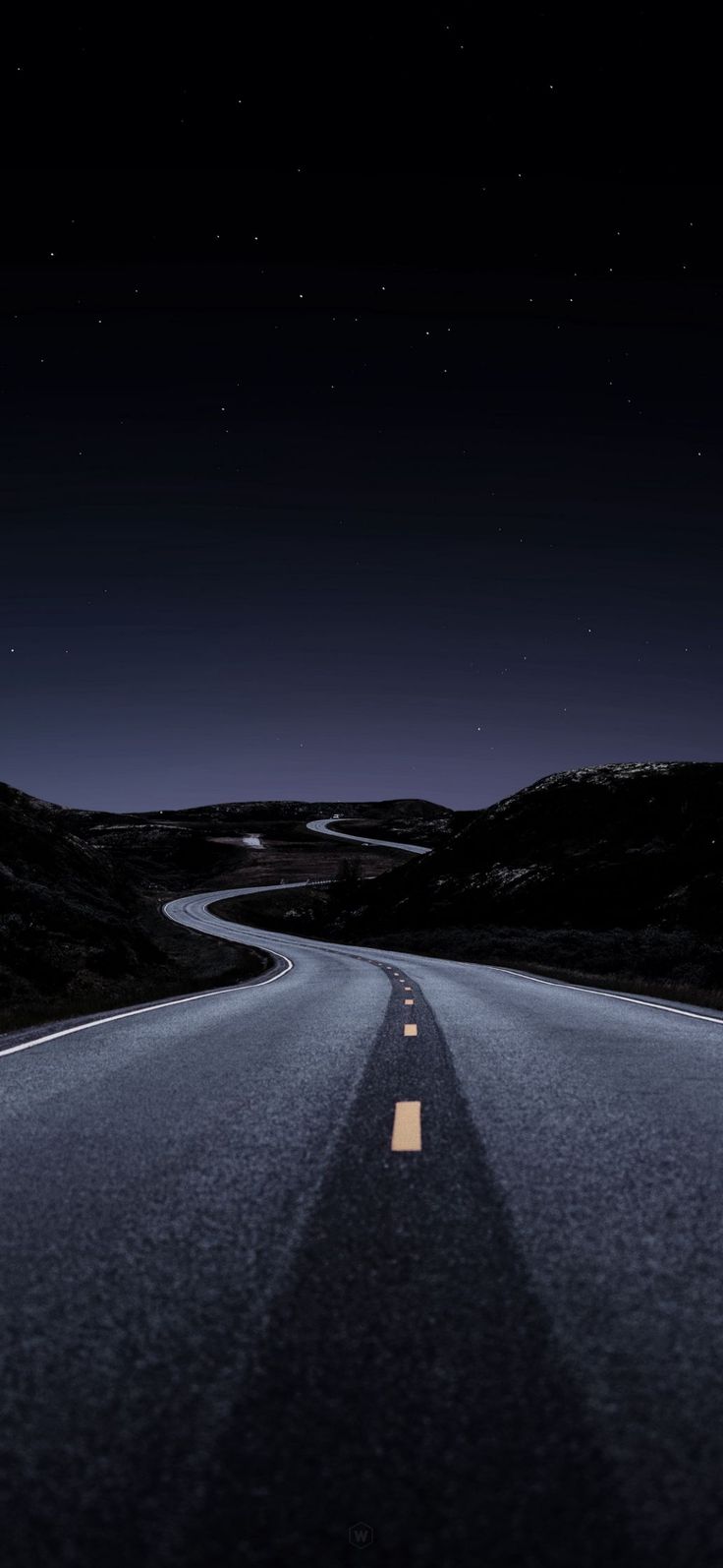 an empty road at night with the moon in the sky and stars on the horizon