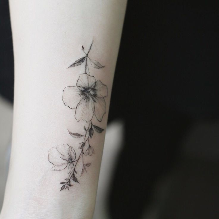 a small flower tattoo on the wrist