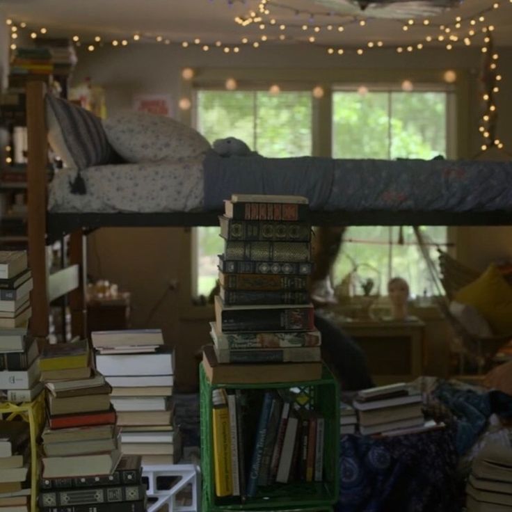 a room filled with lots of books on top of it's shelves next to a bed