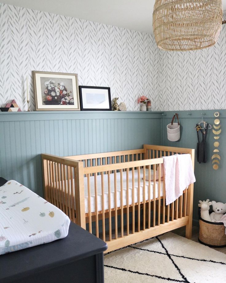 a baby's room with a crib, rug and pictures on the wall