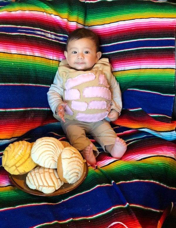 a baby is sitting on a blanket with bread