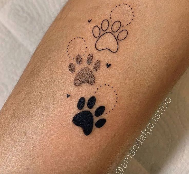 a dog's paw and heart tattoo on the left arm, with black ink