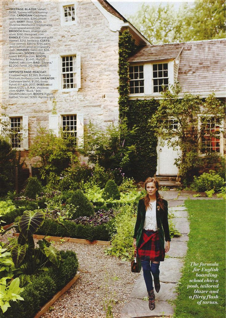 a woman walking down a path in front of a house