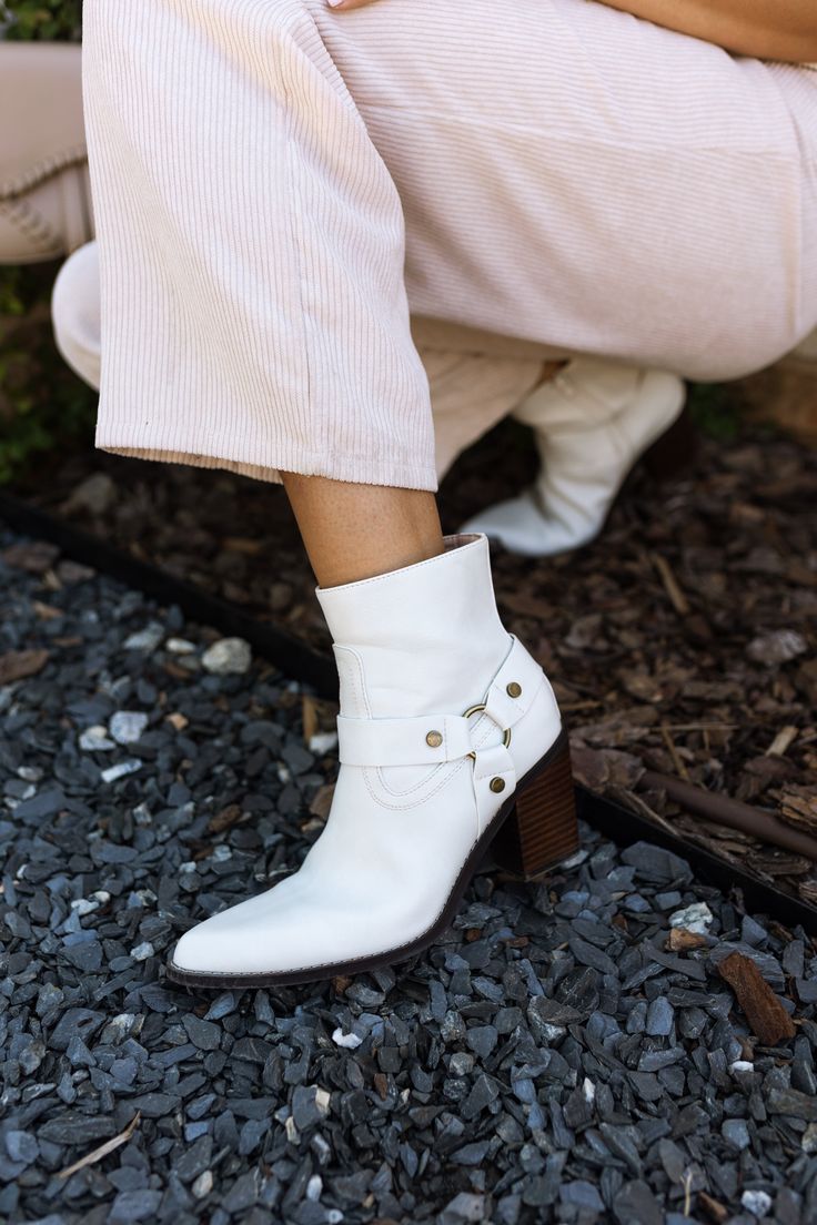 Elevate your footwear collection with the Jackson White Ankle Boots. Featuring pristine white uppers, these boots exude modern sophistication and versatility. The brown block heels provide a stylish contrast and ensure all-day comfort and stability. With convenient inner zippers, slipping them on and off is a breeze, while the outer strap details add a touch of edgy flair. The pointed toes enhance the sleek design, making these boots perfect for any occasion. The Jackson White Ankle Boots seamle White Round Toe Moto Boots For Fall, White Heeled Boots With Reinforced Heel For Fall, White Ankle Moto Boots For Spring, White Boots With Stacked Heel For Fall, White Block Heel Boots For Fall, White Ankle Heeled Boots For Fall, Fall Season White Heeled Boots With Reinforced Heel, White Leather Booties For Fall, Trendy White Boots With Block Heel