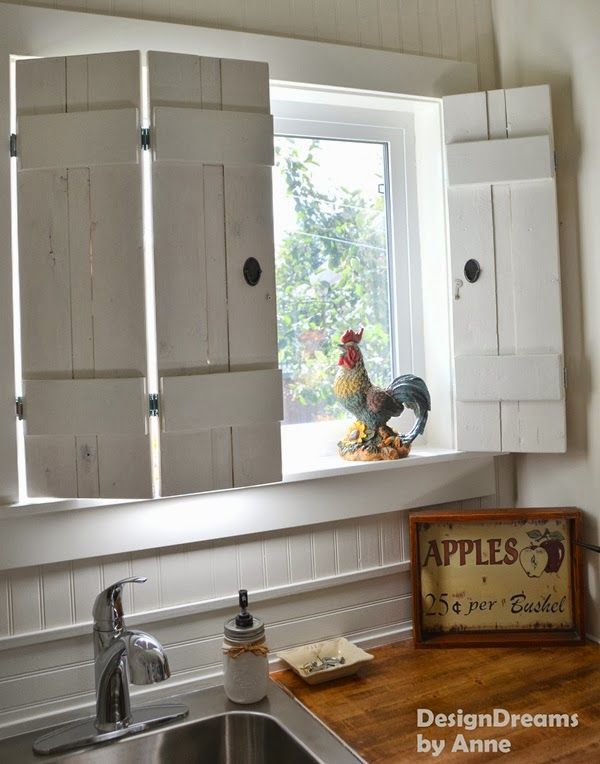 a rooster is standing in the window sill next to an open kitchen door with shutters