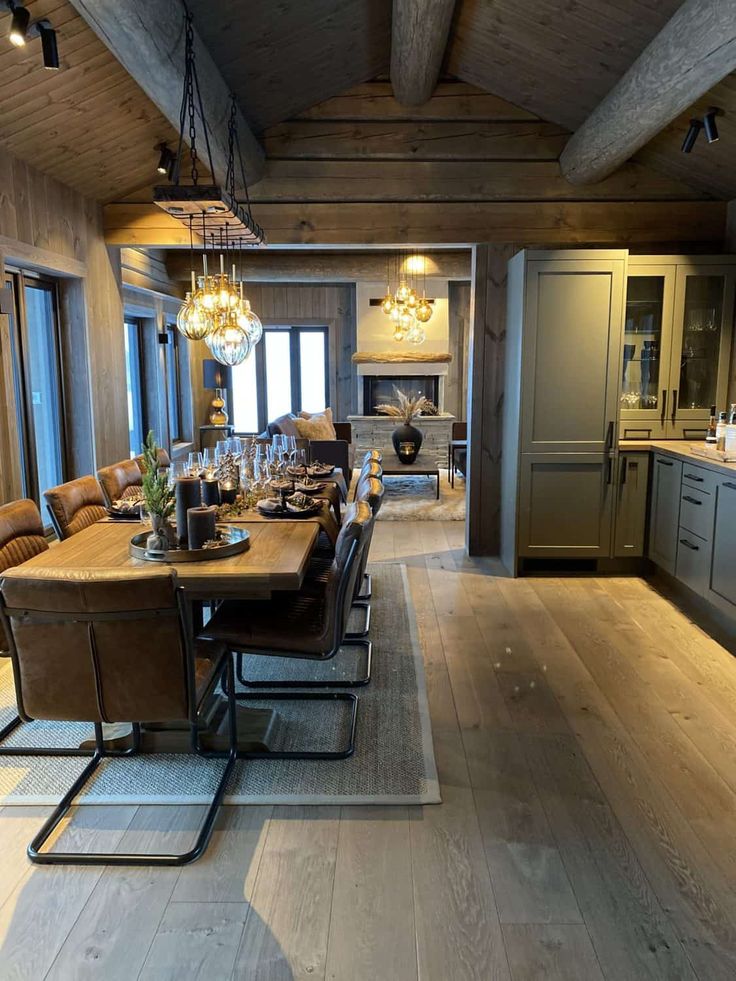 a dining room table and chairs with chandelier hanging from it's ceiling