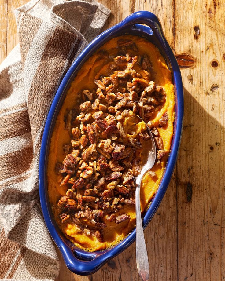 a blue bowl filled with food sitting on top of a wooden table next to a napkin