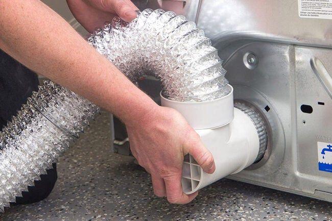 a person using a blow dryer on top of a stove with silver foil covering it