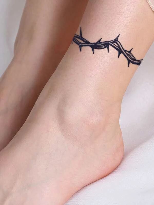 a woman's foot with barbed wire tattoo on the side of her leg,