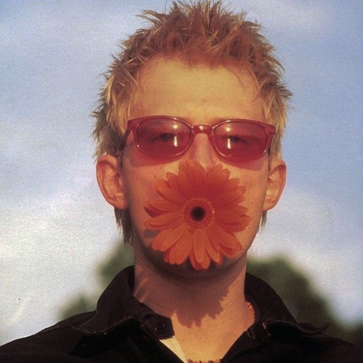 a man with sunglasses and a flower in his mouth