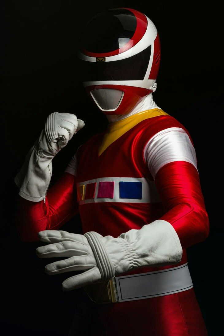 a man in a red and white costume is holding his hand up to his face