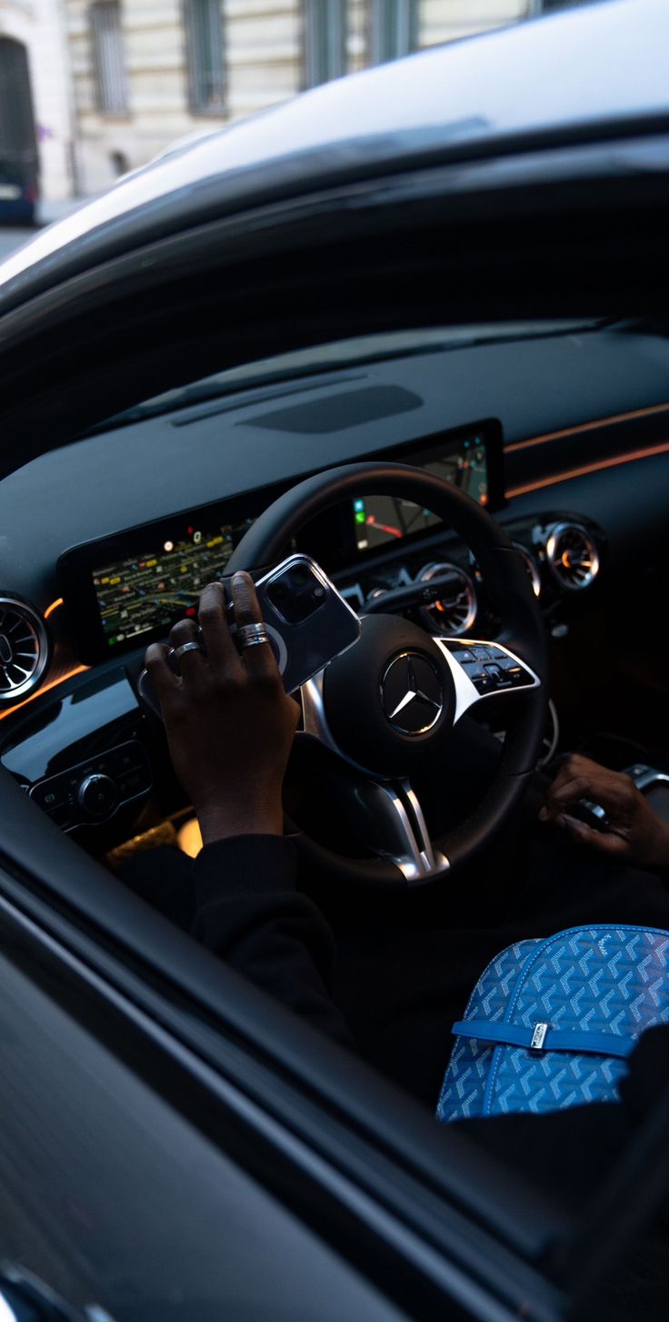 a man driving a car with his hands on the steering wheel