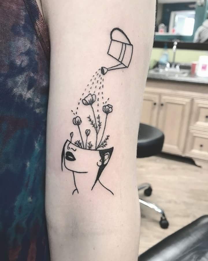 a woman's arm with a black and white drawing of flowers in a vase