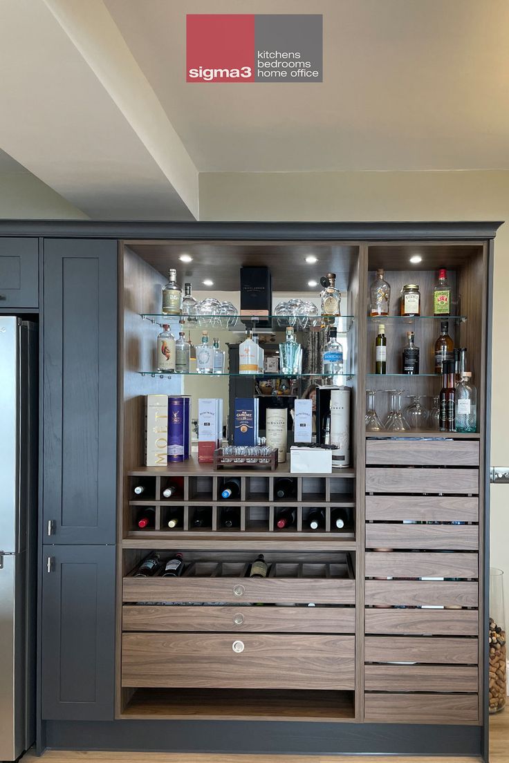 a bar with lots of bottles and glasses on it's glass doored shelves