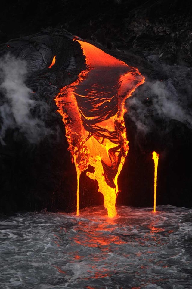 the lava is flowing into the water and it appears to be pouring out from underneath