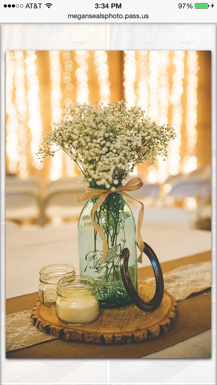 a mason jar with baby's breath sits on a table