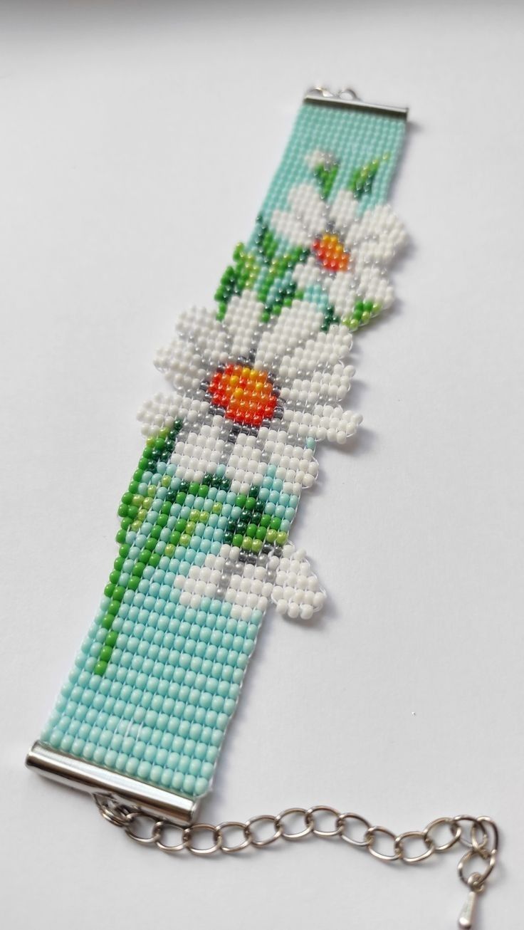 a cross stitch bracelet with flowers on it