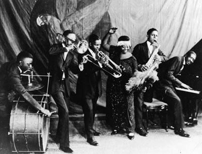 a group of men standing next to each other in front of a drum and trumpet