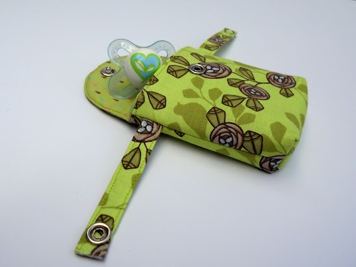 a baby pacifier in a green flowered case