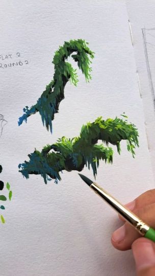 a person is holding a paintbrush and drawing a tree with green leaves on it