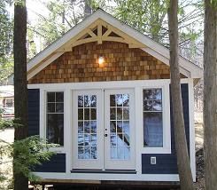 a small cabin in the woods with two doors on it's side and windows open