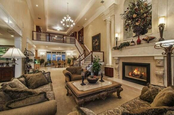 a living room filled with furniture and a fire place in the middle of a room