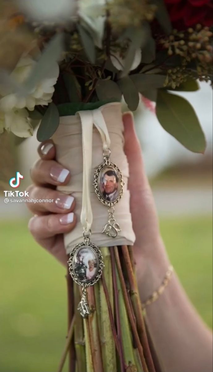 a woman holding a bouquet of flowers in her hands with pictures attached to the stems